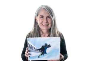 Michelle Carr holding a picture of herself skydiving